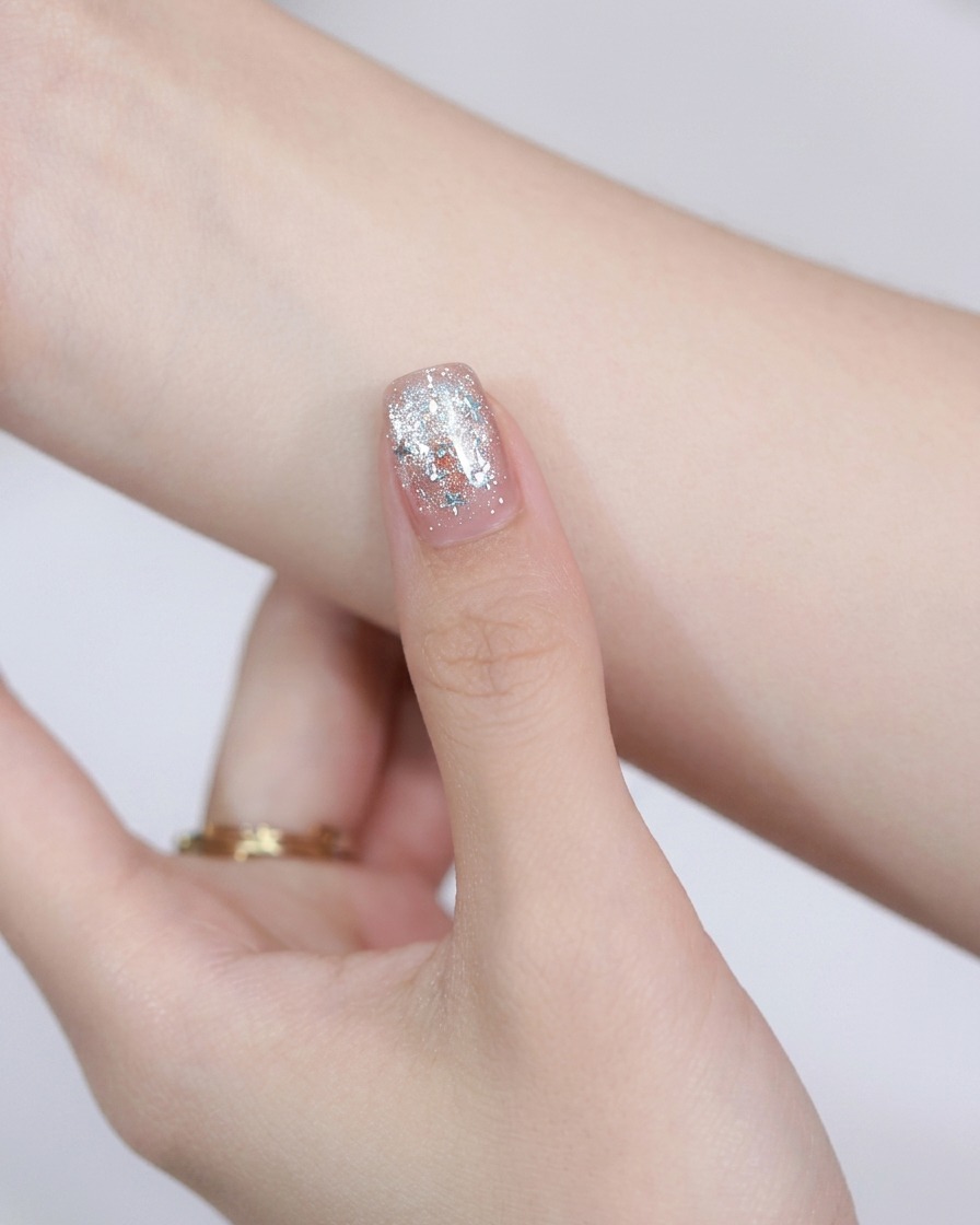 Un magnete rotondo in acciaio tenuto sopra ununghia dipinta per spostare le particelle magnetiche cat-eye.
