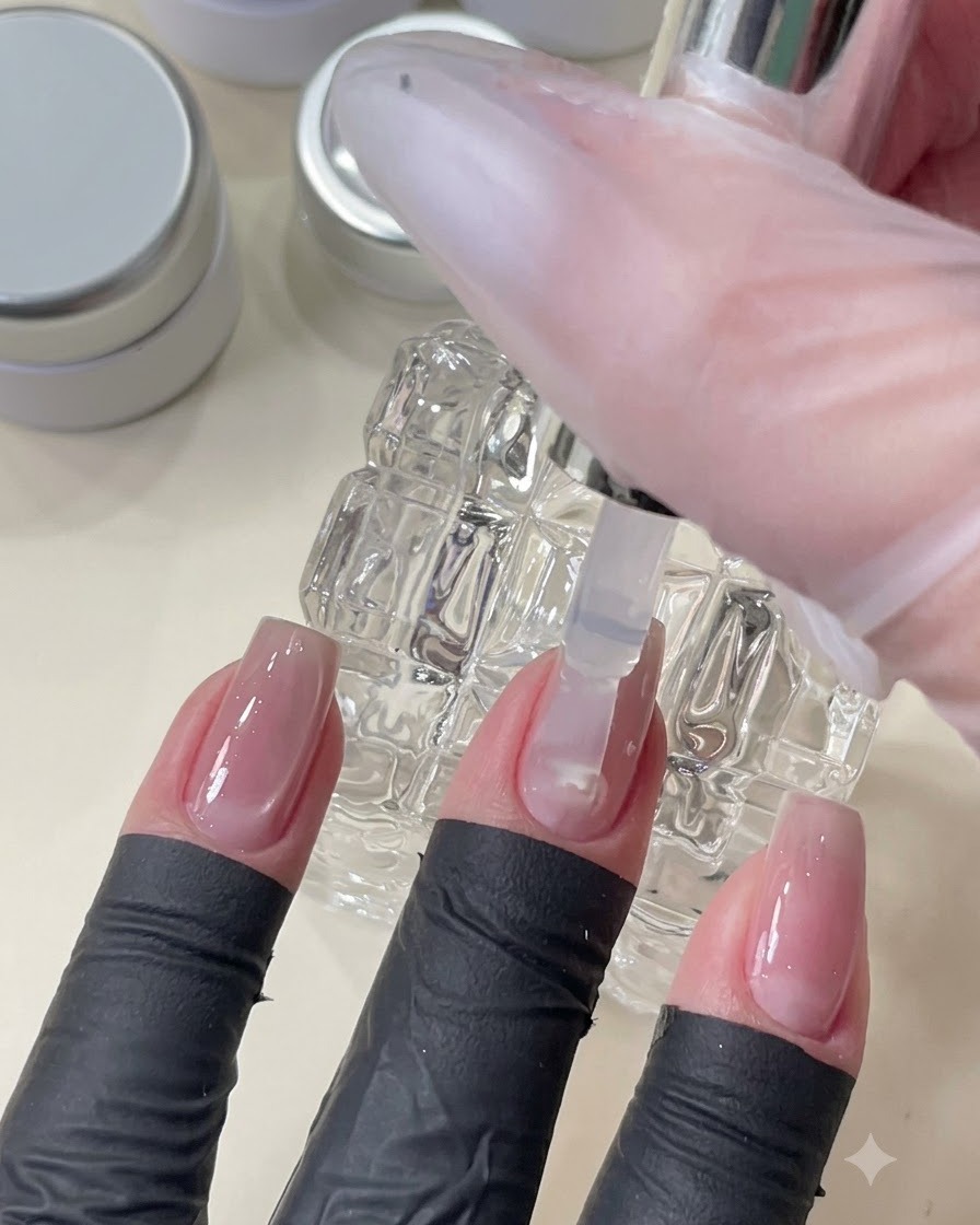 Un pennello che applica un gel top coat trasparente per levigare e livellare la superficie dellunghia sopra la nail art incorporata.