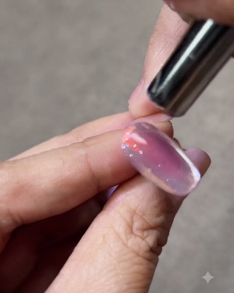 Un piccolo magnete tenuto vicino al lato di ununghia gel cat-eye per modellare la scia luminosa.