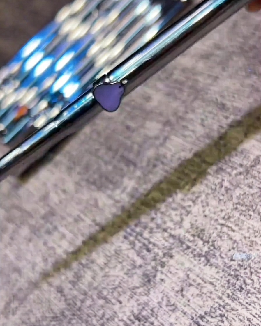 Un pennellino per nail art che applica un top coat lucido su un design finito delle unghie.