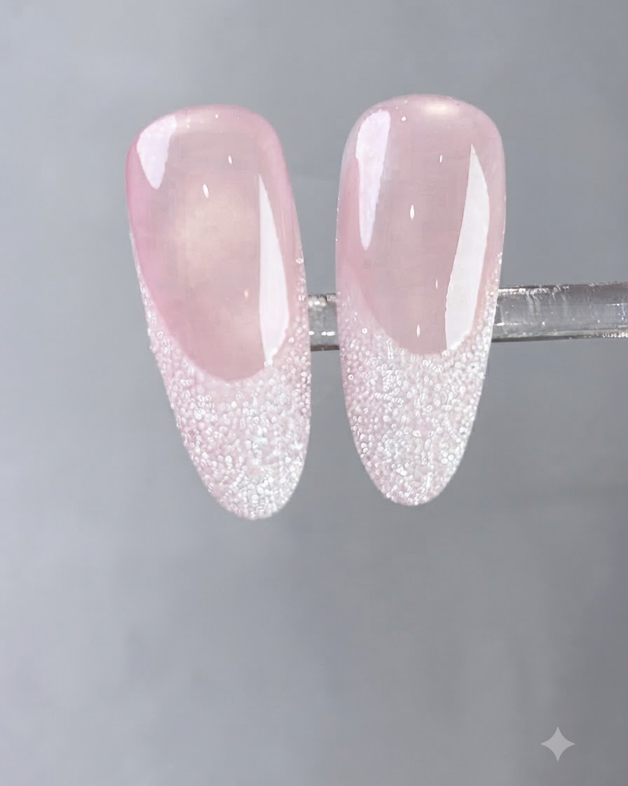 Un pennello applica uno strato di gel bianco latte fluido su ununghia naturale.