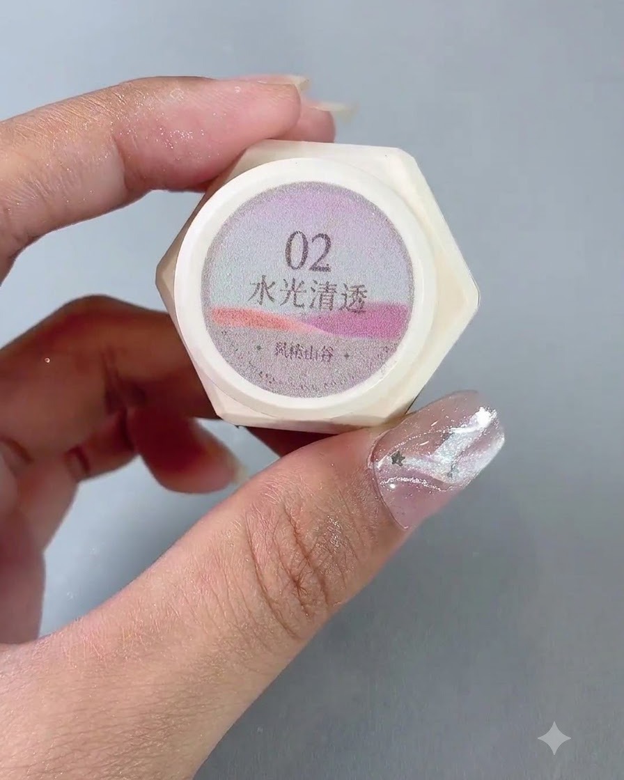 Un paio di mani tengono un barattolo di smalto gel cat eye traslucido numero 2.
