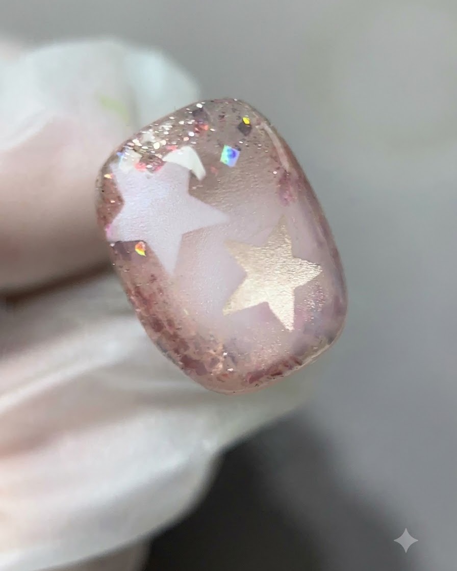 Un primo piano dettagliato che mostra il gel glitterato rosa applicato lungo i bordi dellunghia.