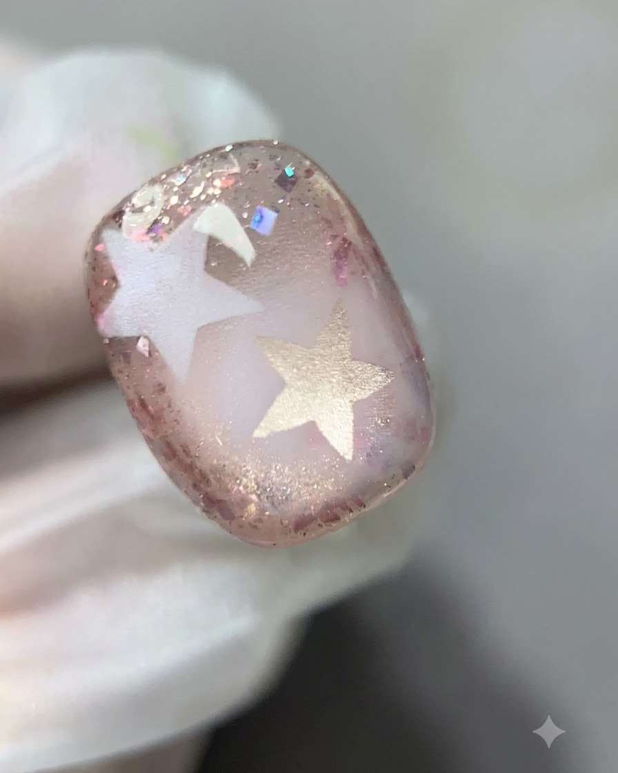 Un pennello che sfuma delicatamente il margine interno del gel glitterato rosa sullunghia.