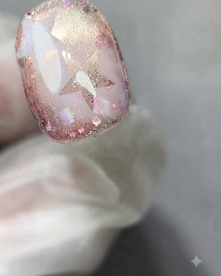 Una spugnetta che tampona delicatamente il gel bianco sopra un adesivo a stella su ununghia decorata.