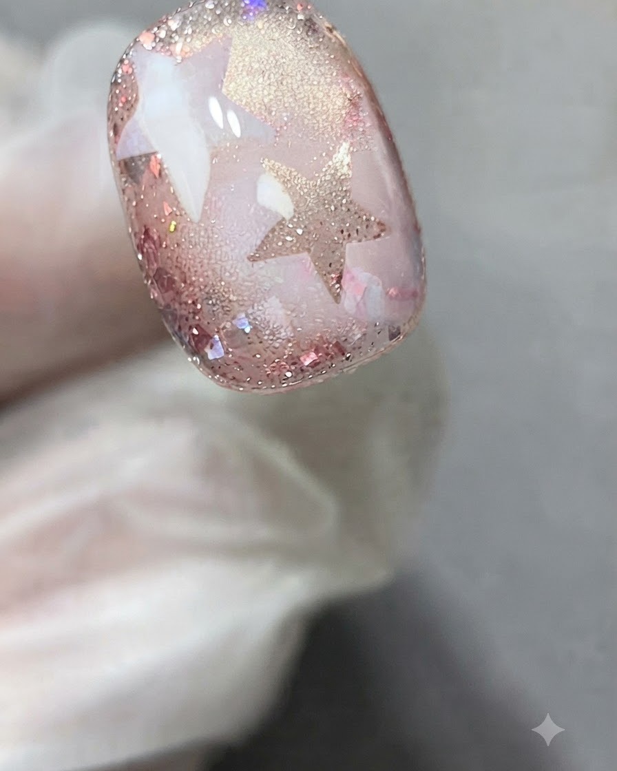 Uno stencil adesivo a stella applicato con precisione sulla superficie di ununghia decorata in gel.