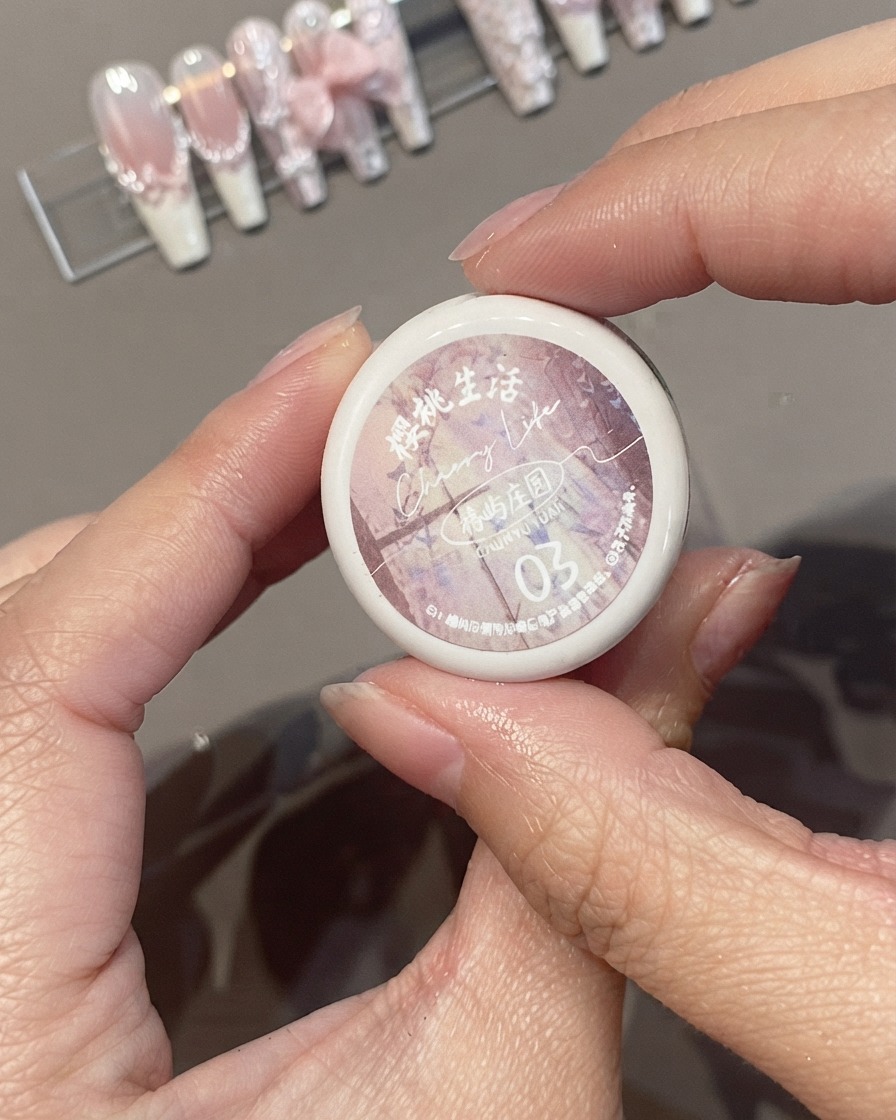 Mani che tengono un vasetto di smalto gel rosa Cherry Life Spring Rain Garden 03.