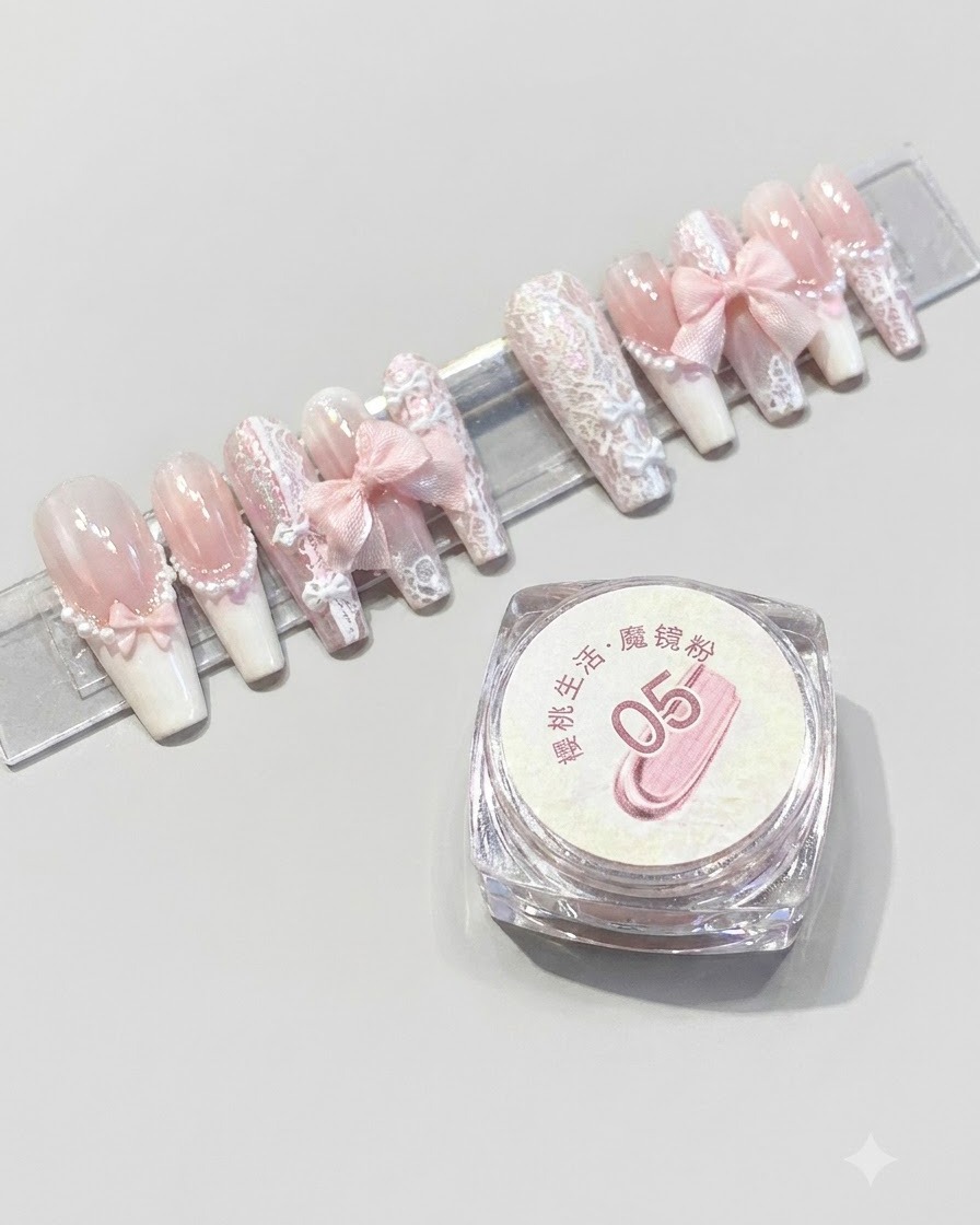 Un contenitore di polvere magica mirror Cherry Life numero 05 posizionato accanto a un espositore di unghie press-on rosa finite.