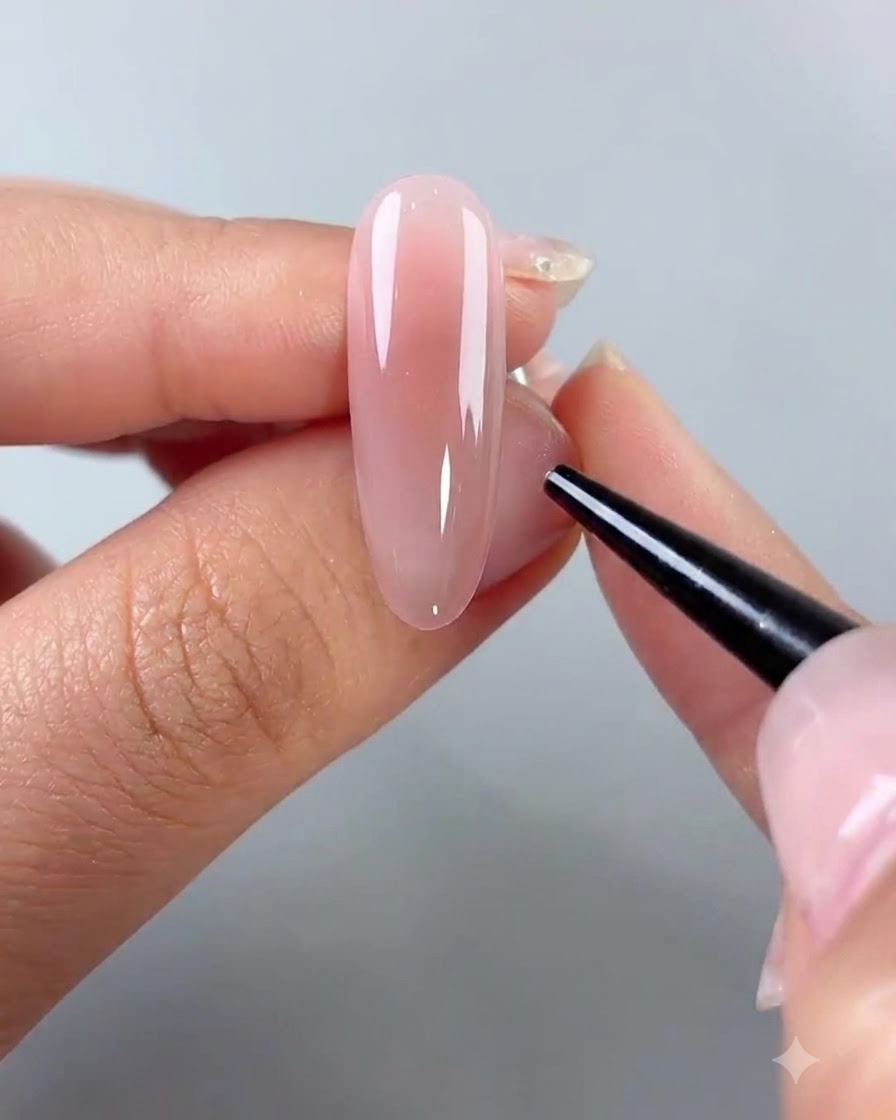 Uno strumento a punta fine posiziona piccoli ornamenti sulla superficie di ununghia rivestita di gel.
