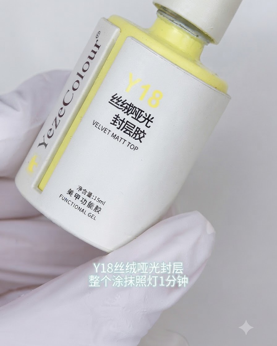 Un flacone di top coat opaco vellutato Y18 tenuto in una mano guantata con etichette in testo coreano visibili.