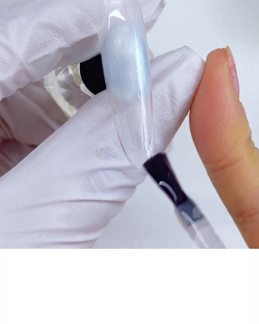 Un pennello che applica il top coat opaco sulla superficie di ununghia.