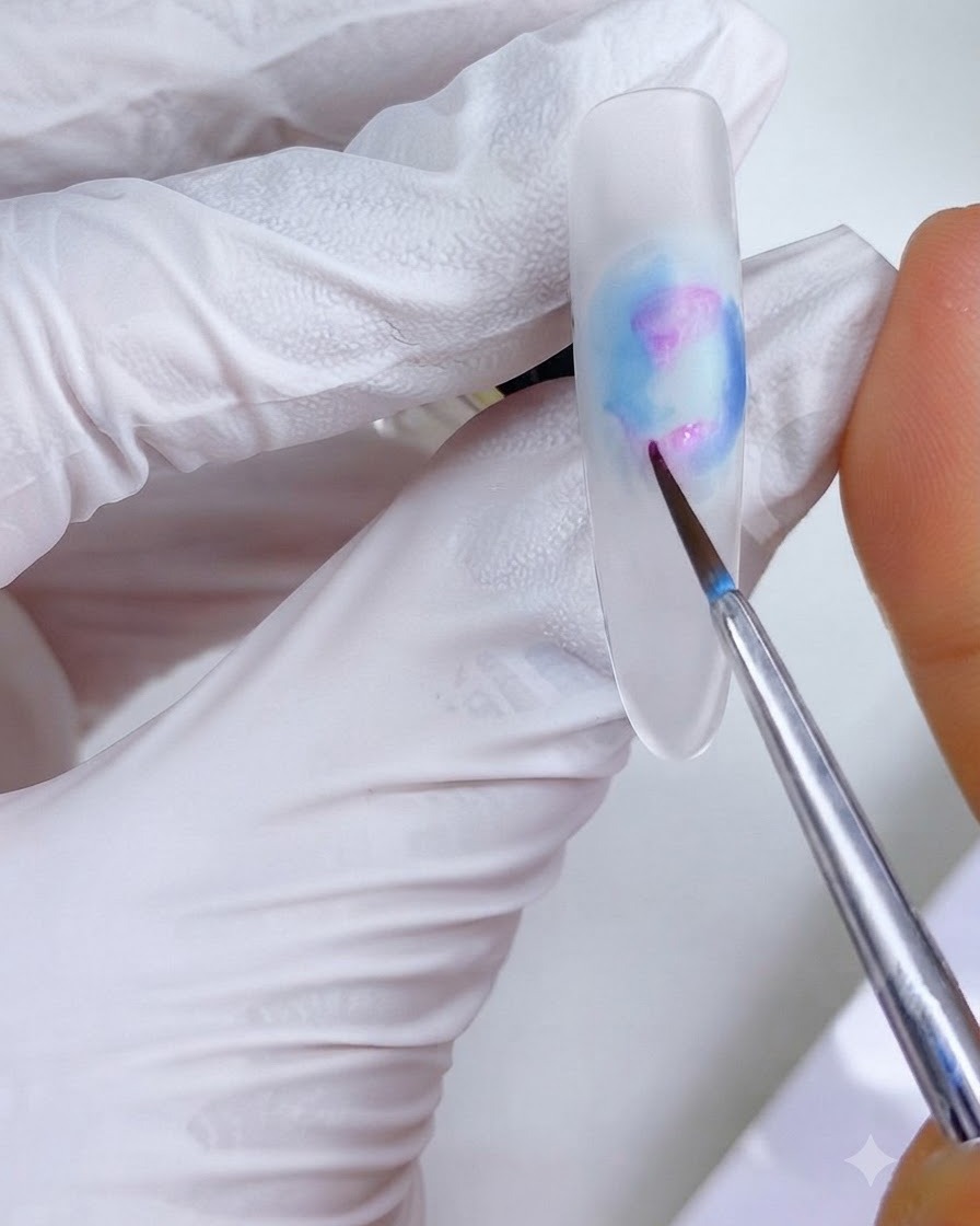 Un pennello per dettagli fini che applica piccoli punti di inchiostro rosa-magenta sulle regioni superiori e inferiori sinistre del design delle unghie.