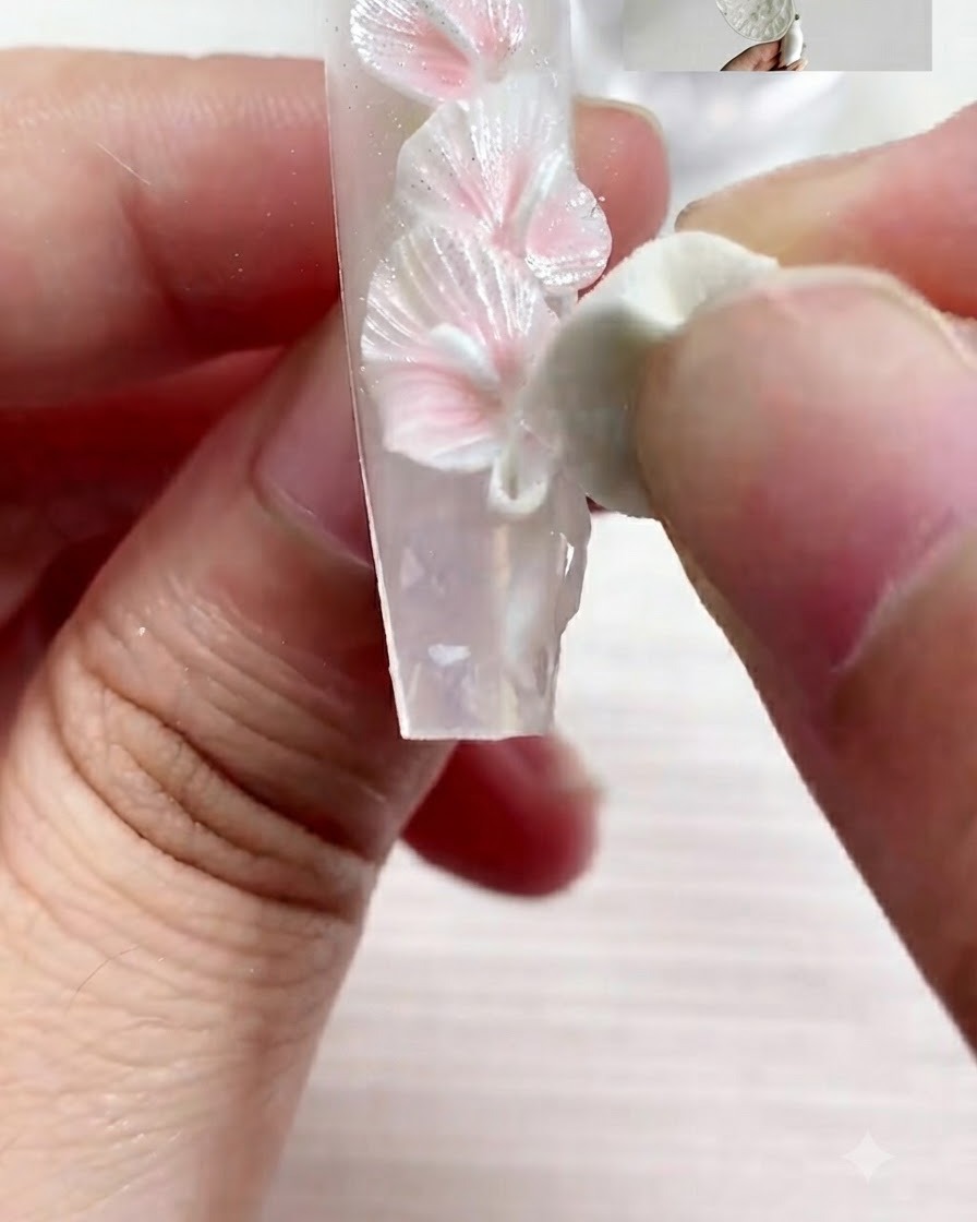Un pennello fine applica accenti dettagliati con il gel S01 sullunghia decorata.
