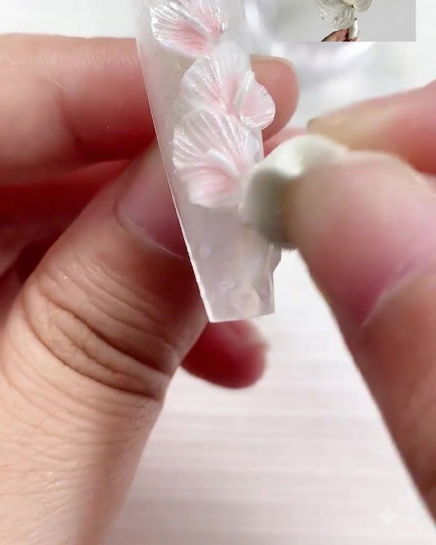 Uno strumento di scultura imprime realistiche linee di venatura nel petalo scolpito.