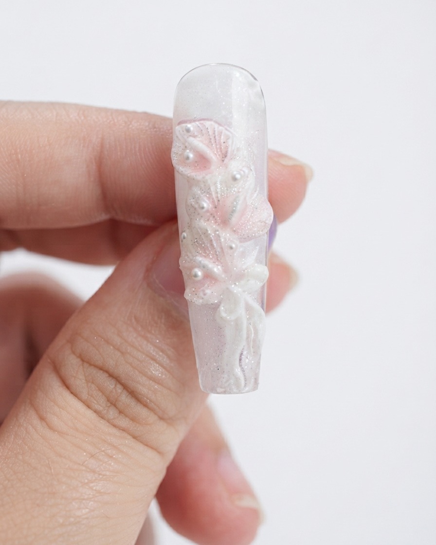 Una spugnetta per make-up tampona del gel rosa chiaro sui petali di calla bianca scolpiti.