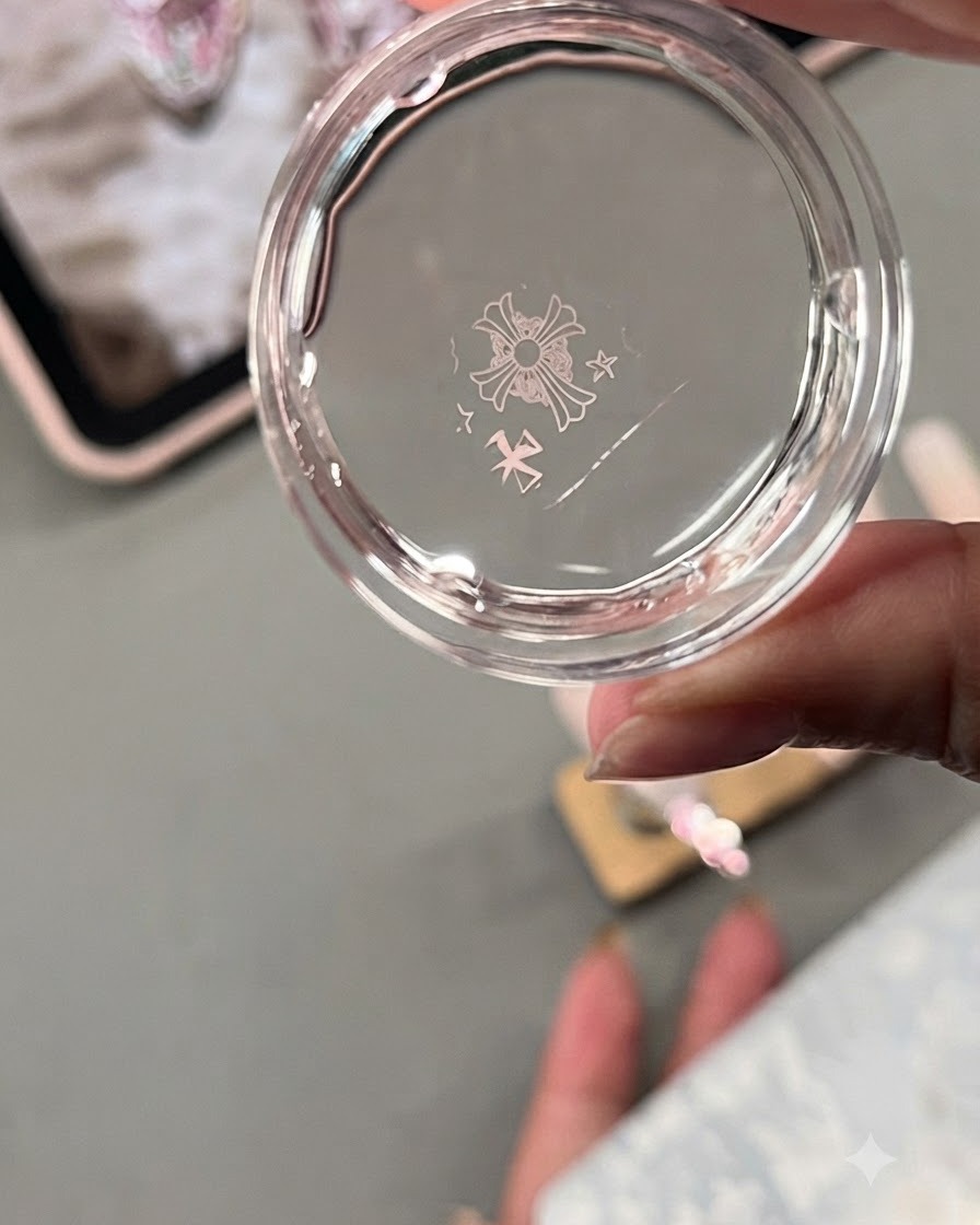 Una testa di stamper in gel trasparente che mostra un design trasferito di croci e stelle in stile Chrome Hearts da una piastra metallica.