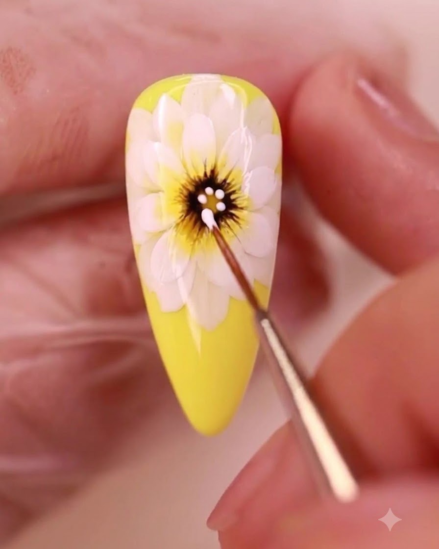 Un pennello di dettaglio applica puntini di gel bianco sul centro scuro di una margherita gialla dipinta.