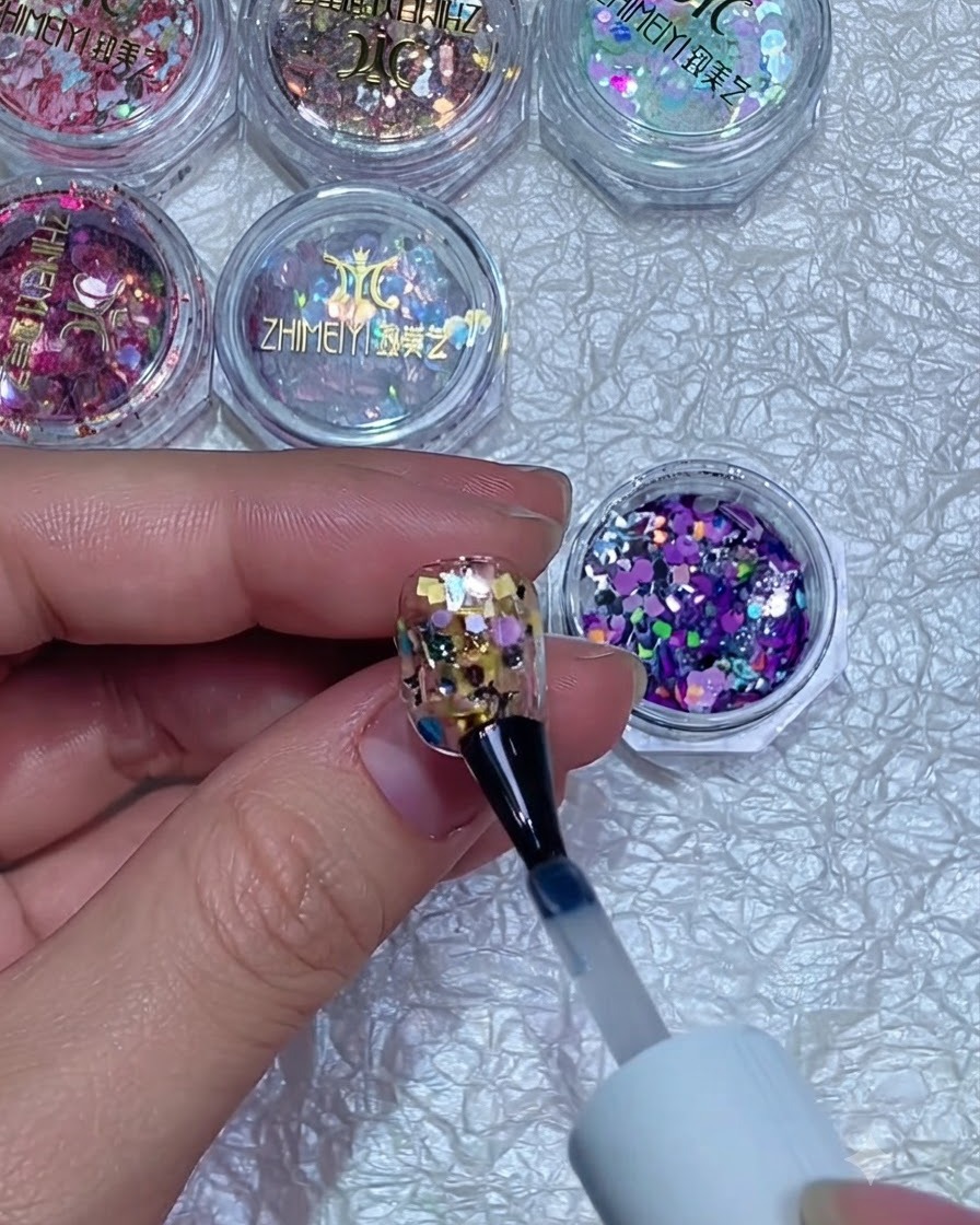 Un buffer per unghie che leviga la superficie di ununghia incapsulata con glitter polimerizzati.