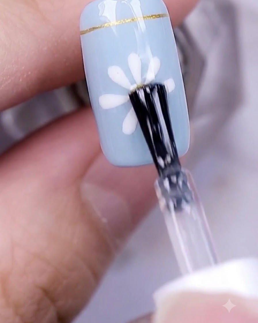Una mano con un design di unghie con margherita finito che polimerizza sotto una lampada professionale per unghie UV.
