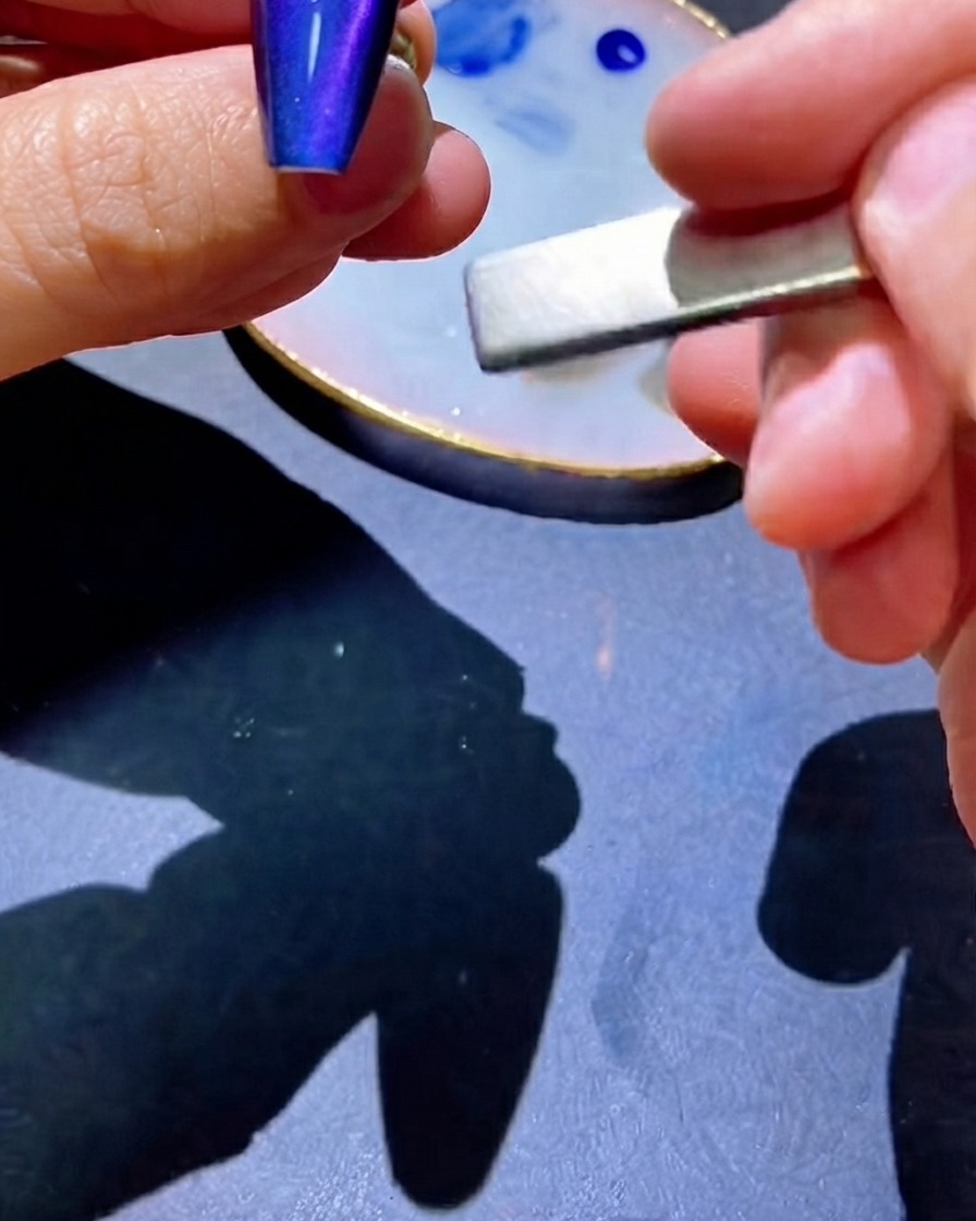 Un magnete utilizzato accanto allunghia per attirare i pigmenti in una linea centrata.