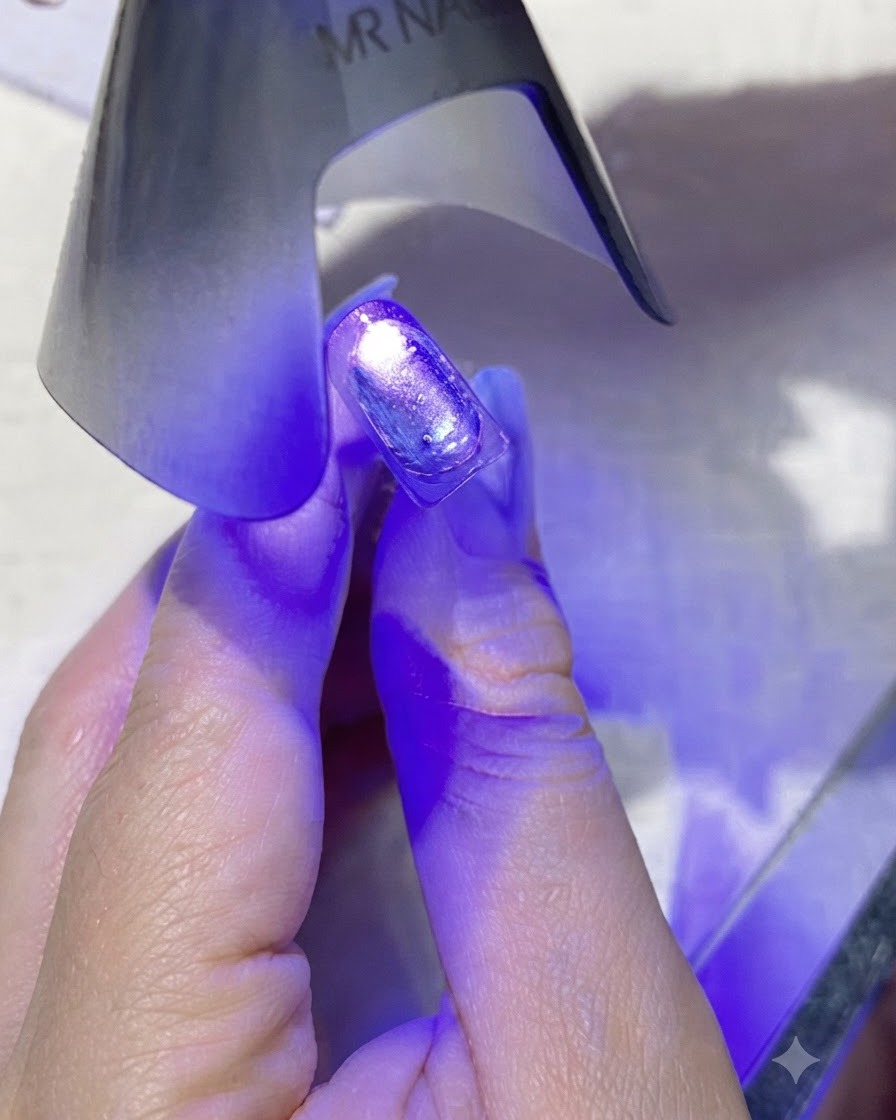 Una mini lampada per unghie UV/LED portatile viola che emette luce viola direttamente su ununghia rivestita.