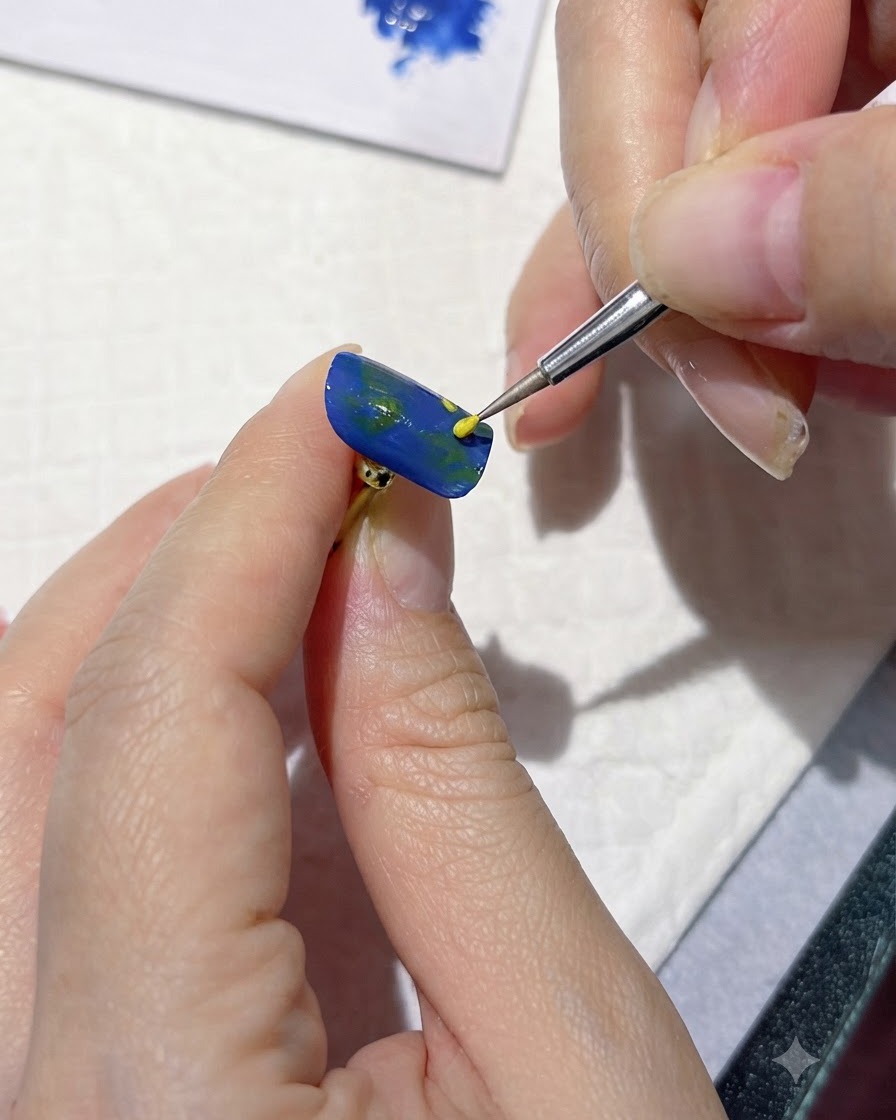 Uno strumento di dettaglio fine che applica punti gialli per segnare i centri dei fiori su ununghia blu.