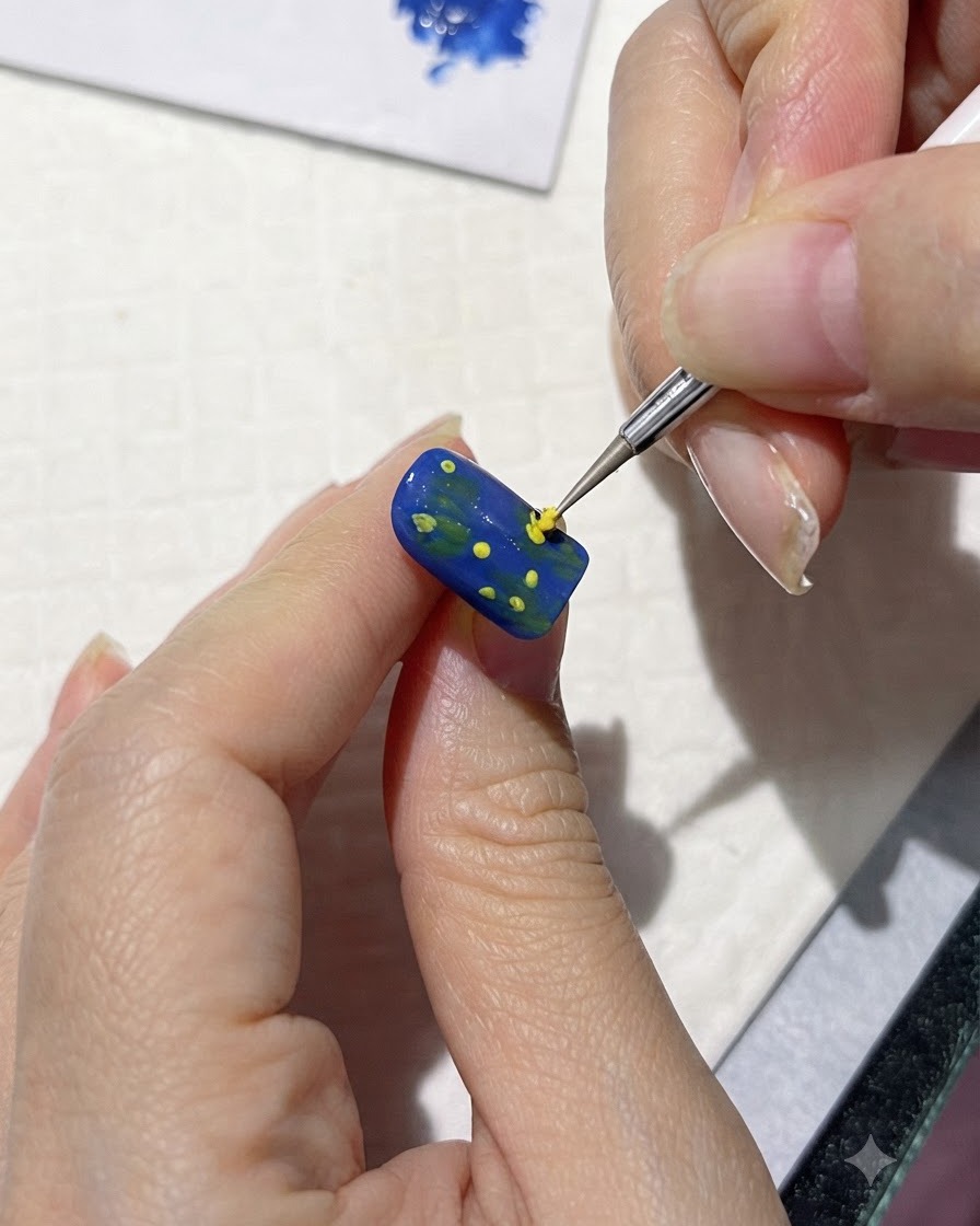 Un pennello fine che dipinge forme di petali gialli sciolti attorno ai punti centrali su ununghia blu.