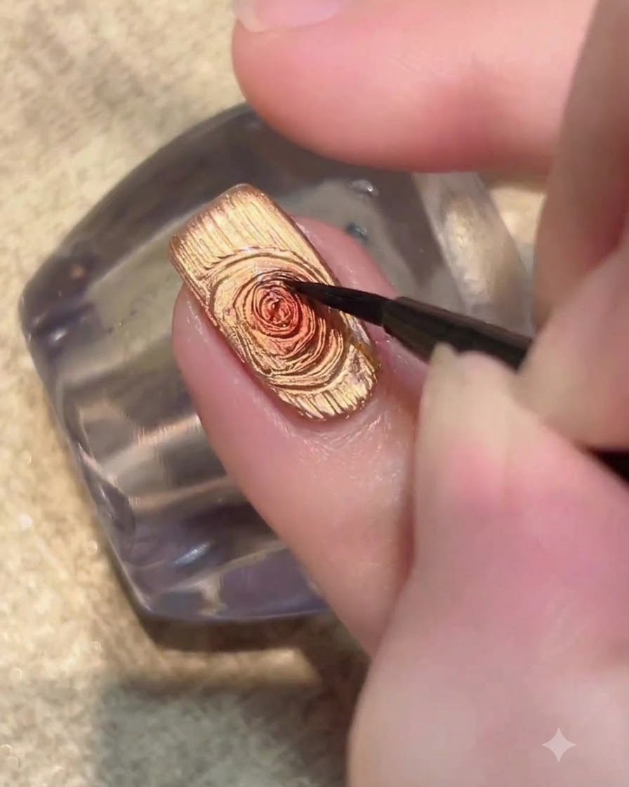 Ununghia illuminata sotto una lampada UV LED mentre polimerizza lo strato di smalto gel cat-eye dorato.