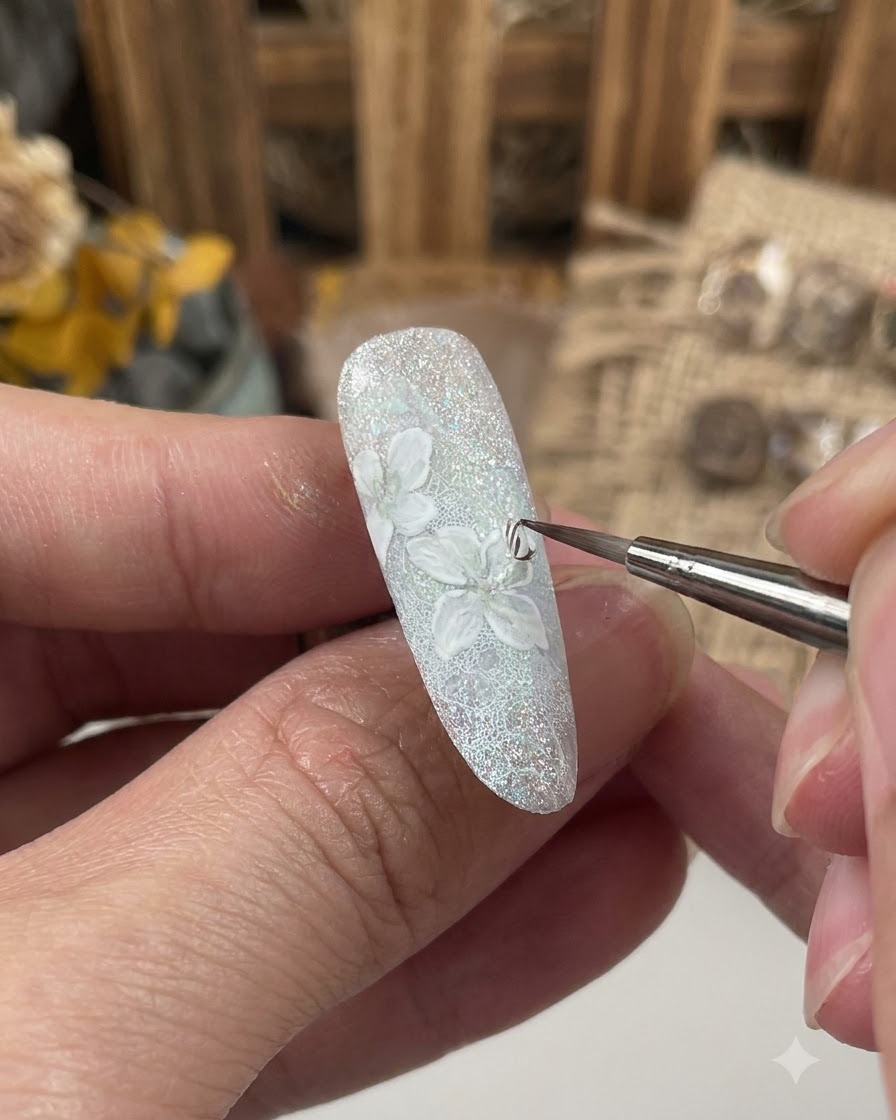 Un pennello fine che applica uno strato di gel sigillante sul design floreale dettagliato su ununghia decorata.