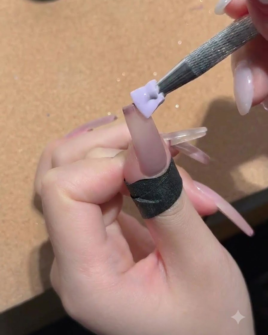 Una piccola spugna tenuta da uno strumento di metallo che tampona il gel nude pesca sulla superficie dellunghia.