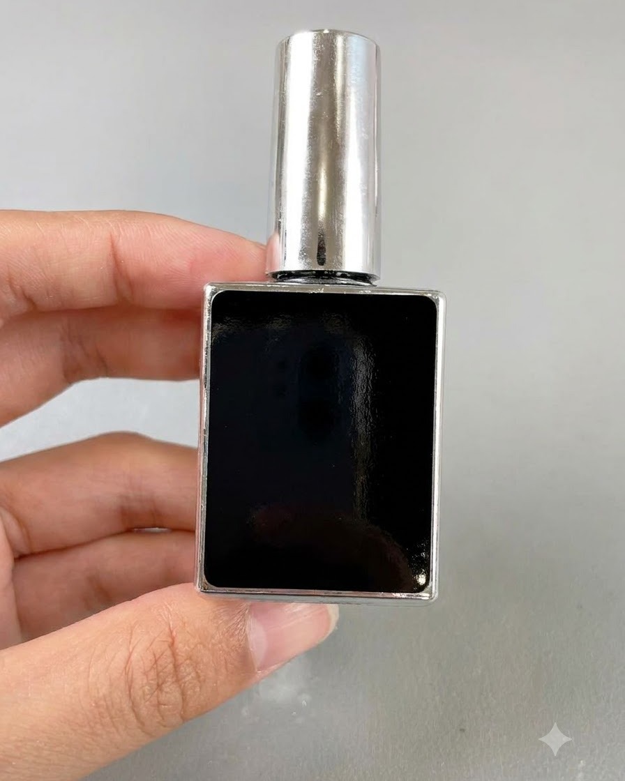 Un piccolo flacone rettangolare nero di gel per unghie tenuto da una mano su uno sfondo neutro.