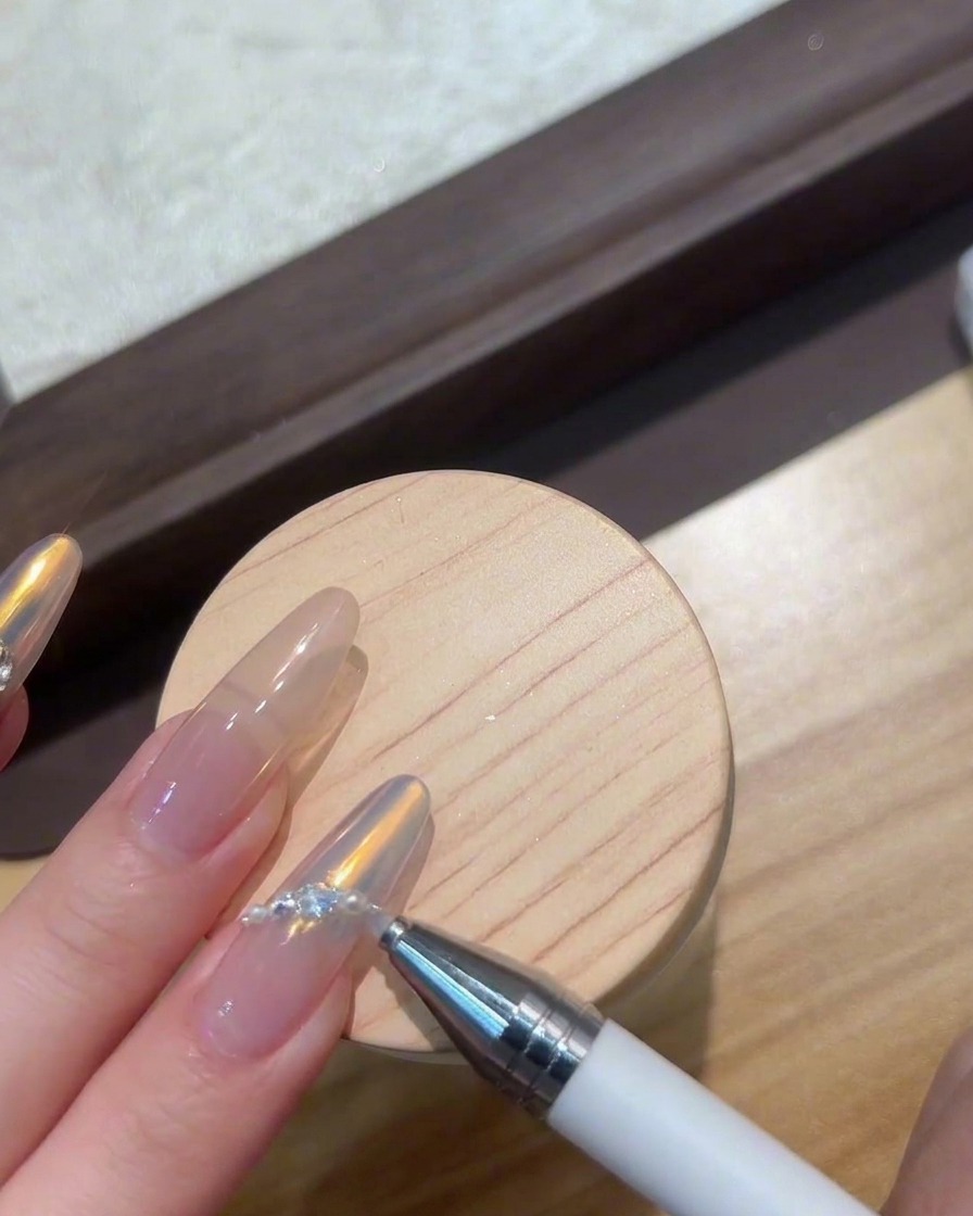 Dita posizionate sotto una lampada UV/LED compatta che polimerizza le gemme di nail art.