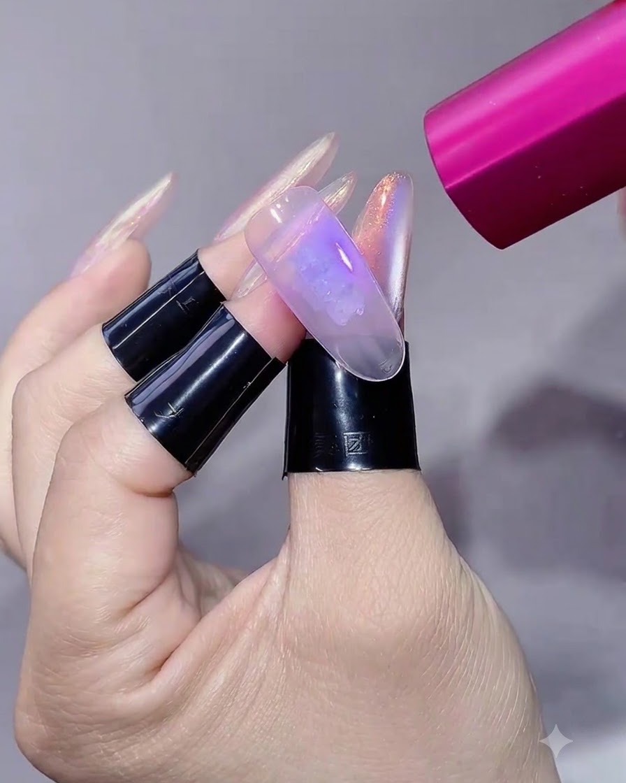 Una lampada UV/LED portatile rosa che illumina ununghia ricostruita e manicurata.