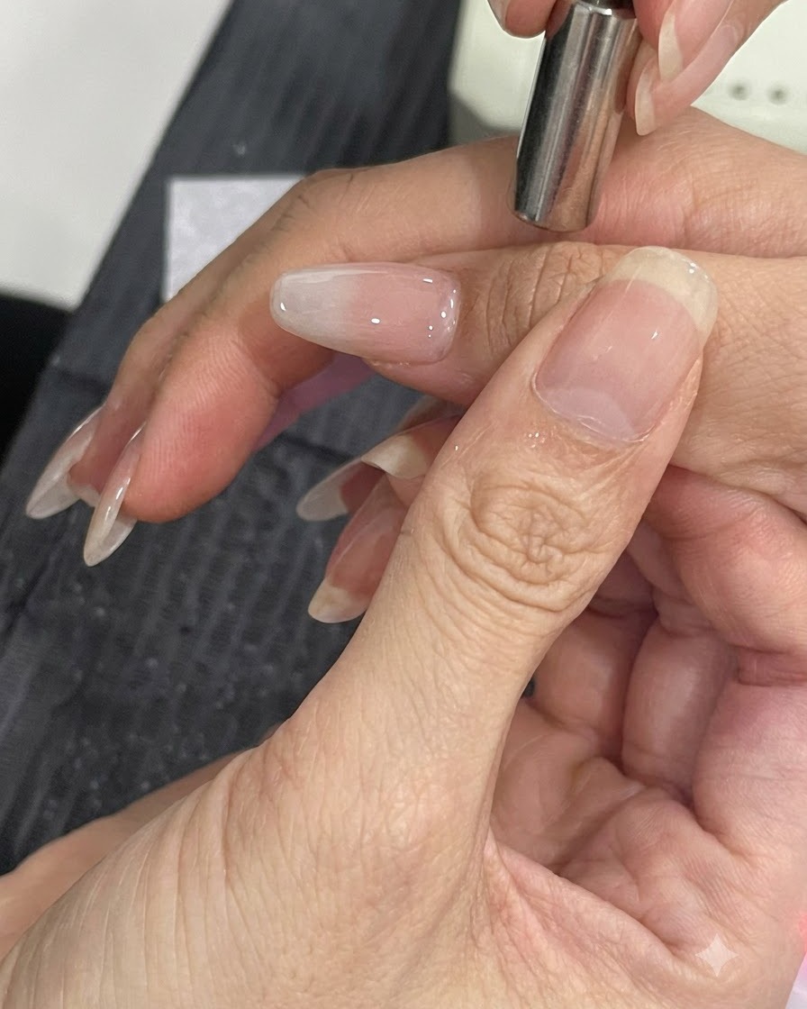 Un piccolo strumento magnetico tenuto vicino al lato di ununghia curata per spostare le particelle di sfarfallio cat-eye.