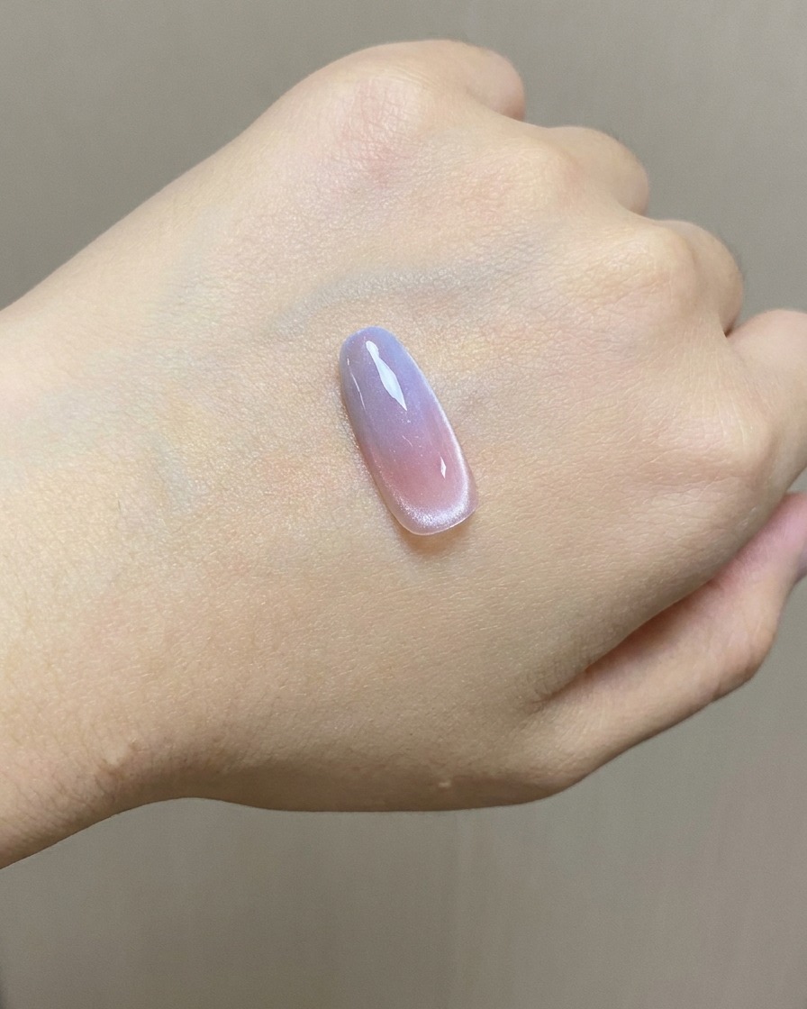 Una spugnetta che applica il gel stamping blu sulla parte superiore di un tip di unghia sfumato.