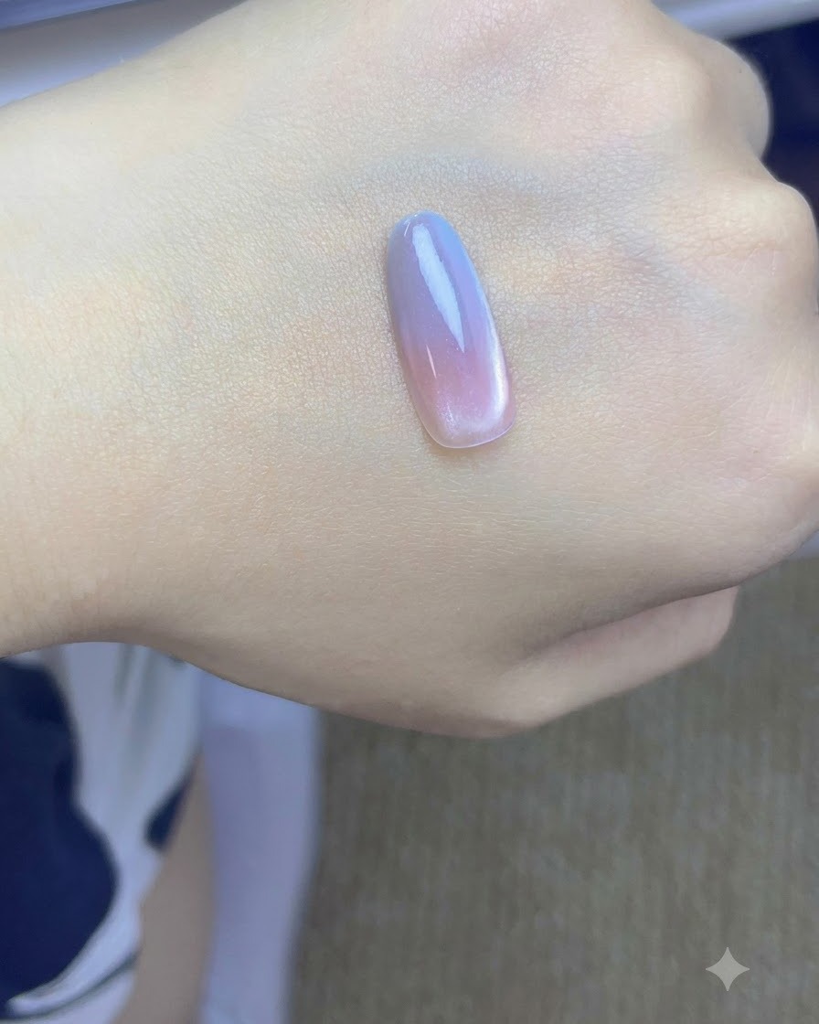 Un tip di unghia con strati sfumati rosa e blu in polimerizzazione sotto una lampada UV/LED.