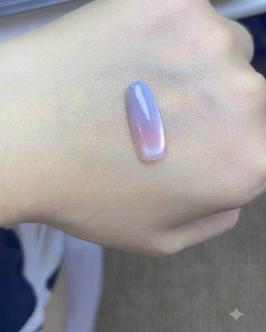 Un pennello che tampona un secondo strato di gel blu sulla punta dellunghia su una mano.