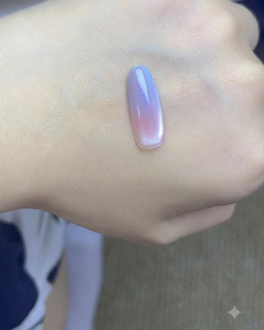 Una piccola calamita tenuta vicina al lato di un tip di unghia dipinto per concentrare le particelle cat-eye.