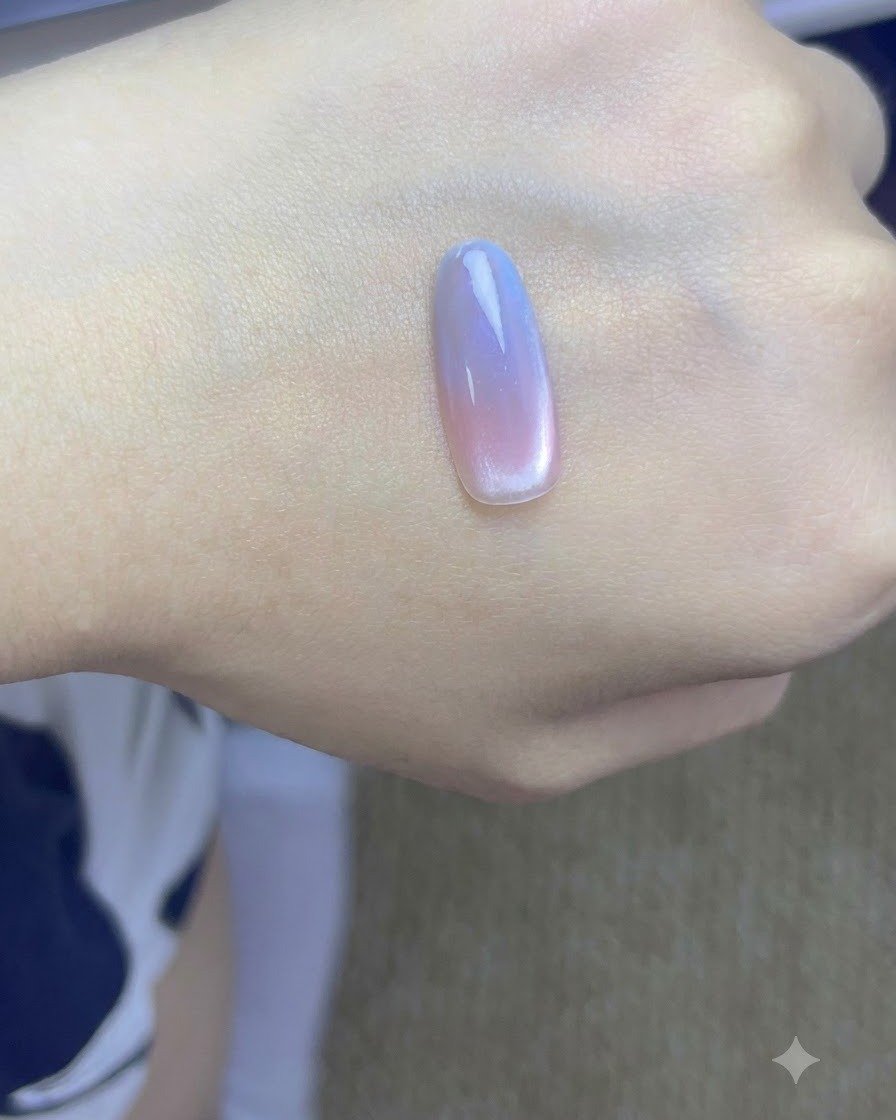 Una mano con unghie cat eye sfumate finite in fase di polimerizzazione sotto una lampada professionale per unghie UV.