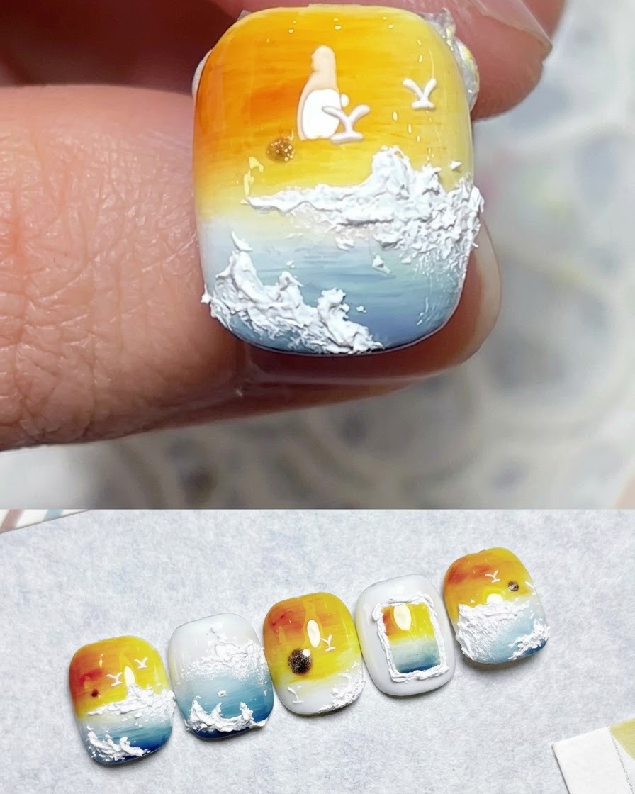 Un pennello che applica il top coat sopra un design finito di nail art con gradiente tramonto.