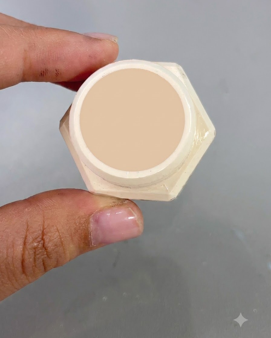 Un barattolo aperto di gel oro chiaro fluido n. 2 mostrato in primo piano davanti a uno sfondo per unghie.