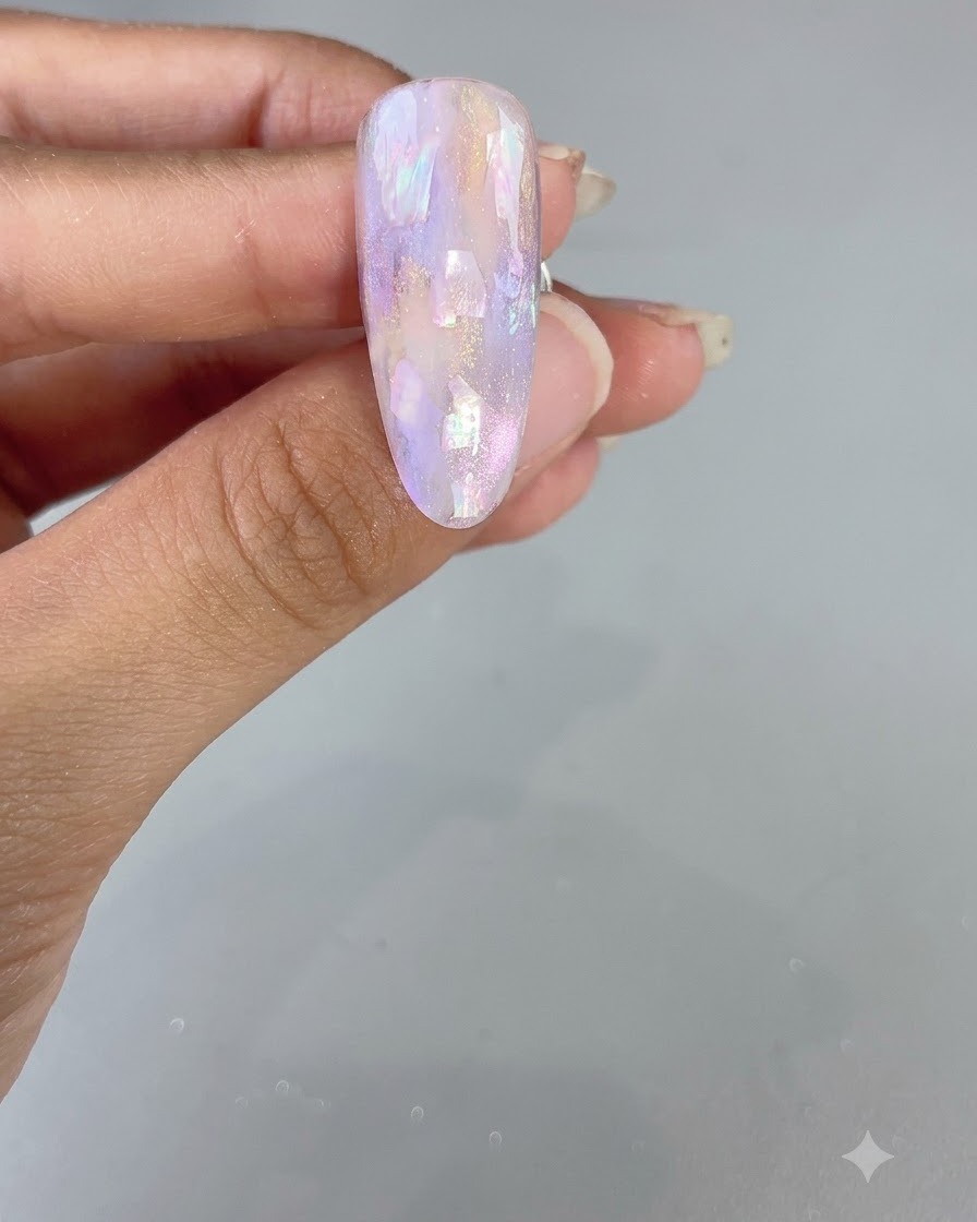 Ununghia finita a mandorla caratterizzata da un design lucido in acquarello viola e conchiglie.