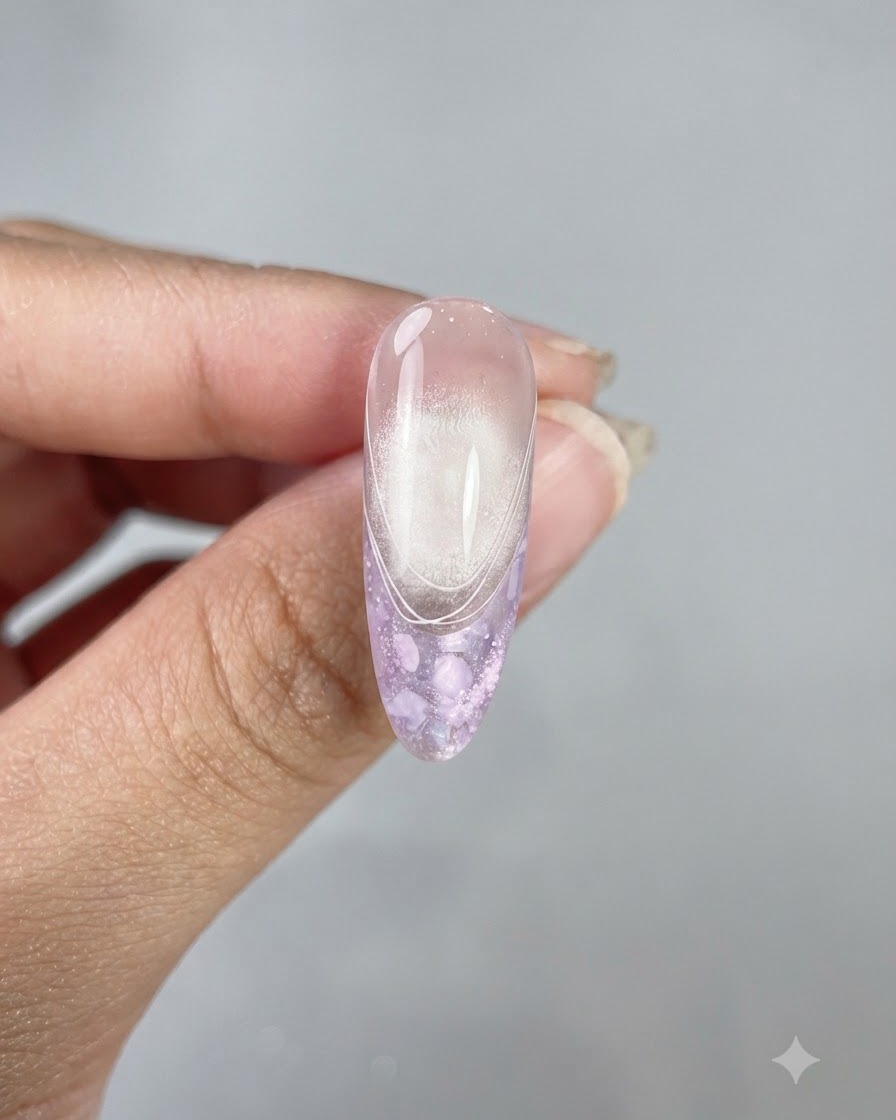 Ununghia lunga a mandorla finita che mostra un top coat lucido, una finitura cat eye e delicate linee french bianche.