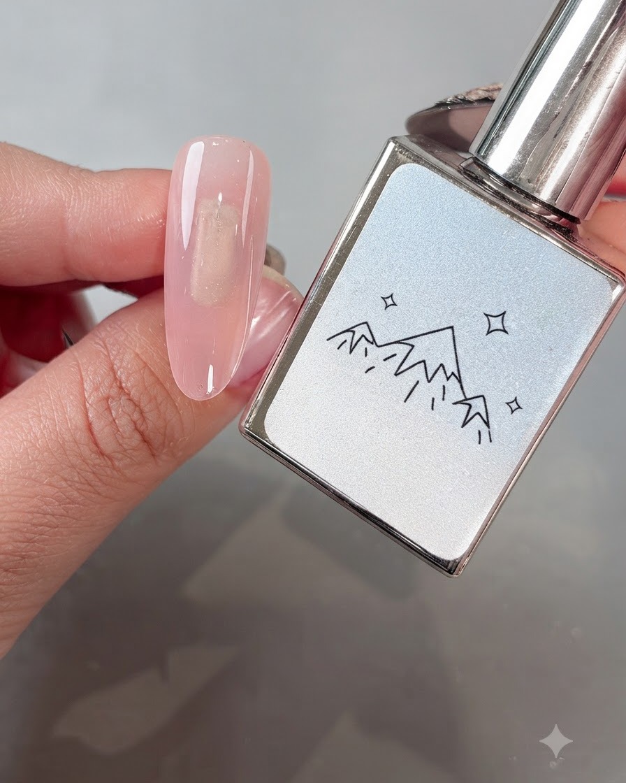 Un pennello che applica uniformemente il gel cat-eye White Boiling Water No. 2 su ununghia con base rosa.