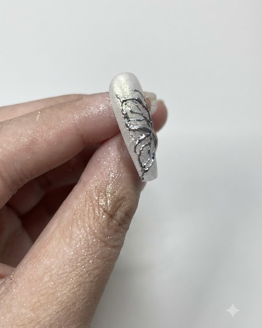 Un pennello soffice per la polvere che rimuove la polvere cromo argento in eccesso dai bordi di ununghia curata.