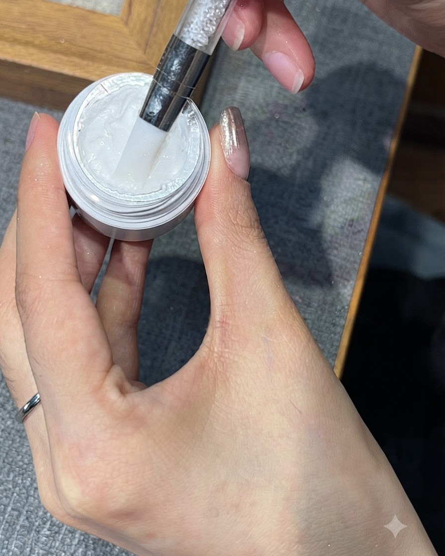 Uno strumento che preleva una piccola quantità di gel per stamping bianco dal suo vasetto.