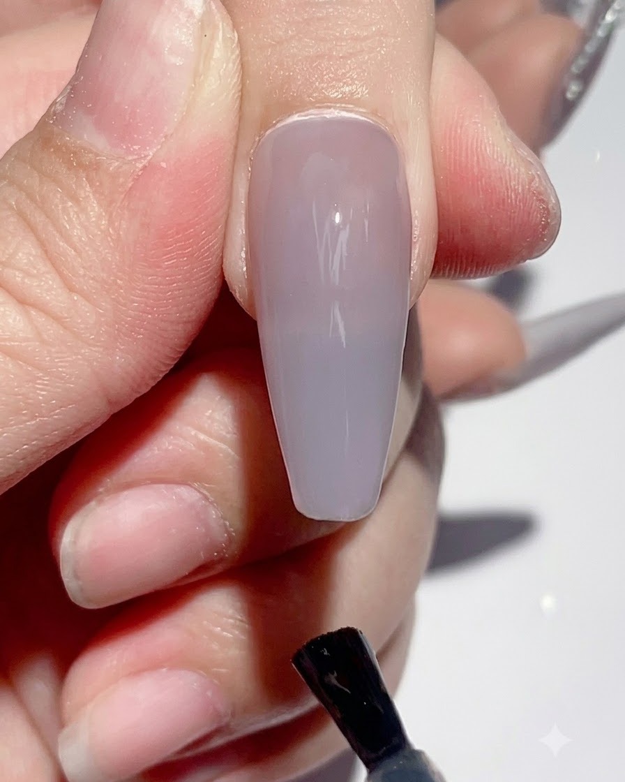 Una mano posizionata sotto una lampada UV LED per unghie durante il processo di polimerizzazione.