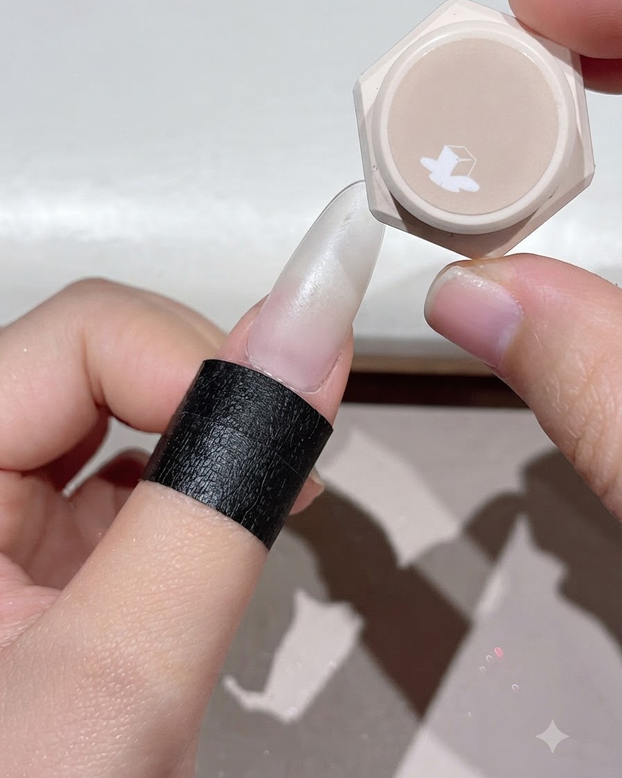 Un dito posizionato sotto una lampada per unghie UV o LED per polimerizzare lo strato di gel applicato.