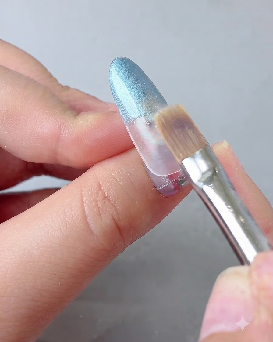 Un pennello da sfumatura che ammorbidisce delicatamente la transizione del gel blu su ununghia.