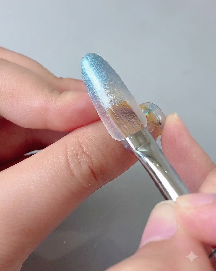 Uno strumento magnetico tenuto vicino alla punta dellunghia in gel blu per concentrare la brillantezza cat eye.